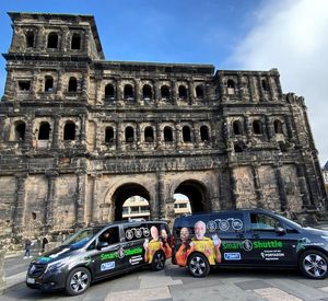 Das Foto zeigt zwei Elektro-Minibusse vor der Porta Nigra in Trier