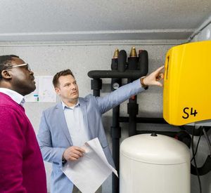 Das Bild zeigt Paul Ngahan von der Energieagentur Rheinland-Pfalz (links) und Sascha Bub, Mitarbeiter der Stadtwerke Schifferstadt, beim Entlüften der Soleleitung im Keller eines Abnehmers. 