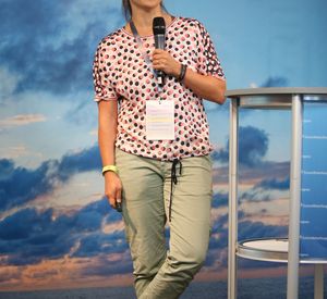 Das Bild zeigt eine Person mit einem Mikrofon