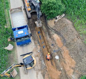 Das Bild zeigt aus Vogelperspektive eine Baustelle mit LKW und Bagger