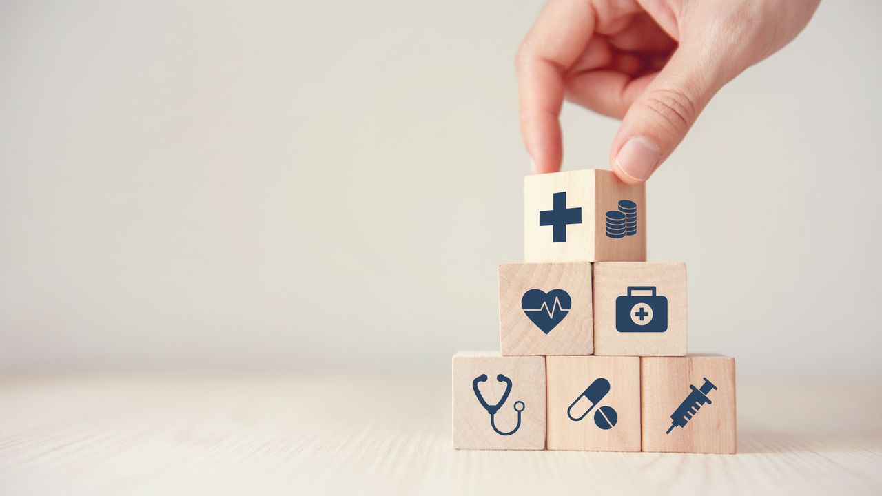Das Bild zeigt sechs Holzwürfel mit Symbolen aus der Medizin