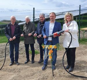 Das Foto zeigt fünf Personen mit einem Stecker