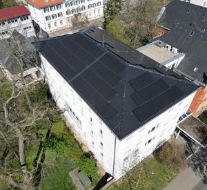 Das Bild zeigt ein Rathaus mit PV-Anlage von oben