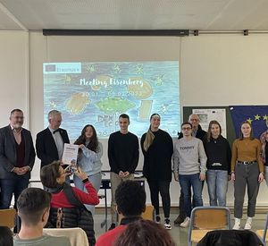 Das Foto zeigt Landrat Rainer Guth und Klimaschutzmanagerin Lena Gilcher mit Schülern in einem Klassenraumen und Schüler in Eisenberg als Klimahelden aus.  