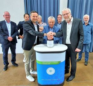 Das Bild zeigt mehrere Männer um einen Startknopf