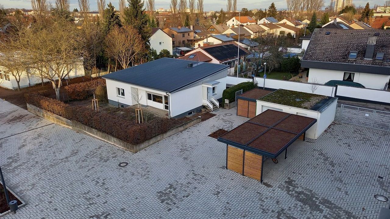 Das Bild zeigt eine Müllleinhausung mit Dachbegrünung auf einem Schulhof