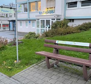 Das Schild zum Umdrehen hängt am Mast neben der Bank.