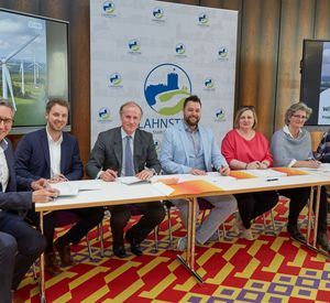 Das Bild zeigt mehrere Personen bei der Vertragsunterzeichnung