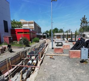 Das Bild zeigt die Verlegung von Rohren am Schulzentrum Schifferstadt, um dieses an das Nahwärmenetz anzuschließen.