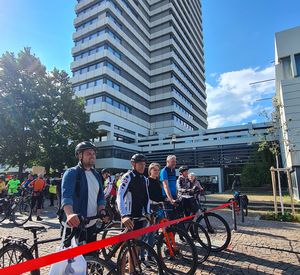 38_StadtKaiserslautern.jpg Das Bild zeigt mehrere Personen, die mit ihrem hinter Fahrrädern hinter einem roten Band stehen.