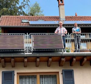 Das Foto zeigt zwei Personen auf einem Balkon mit installiertem Balkonkraftwerk