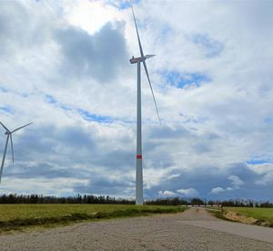 Das Foto zeigt zwei Windräder